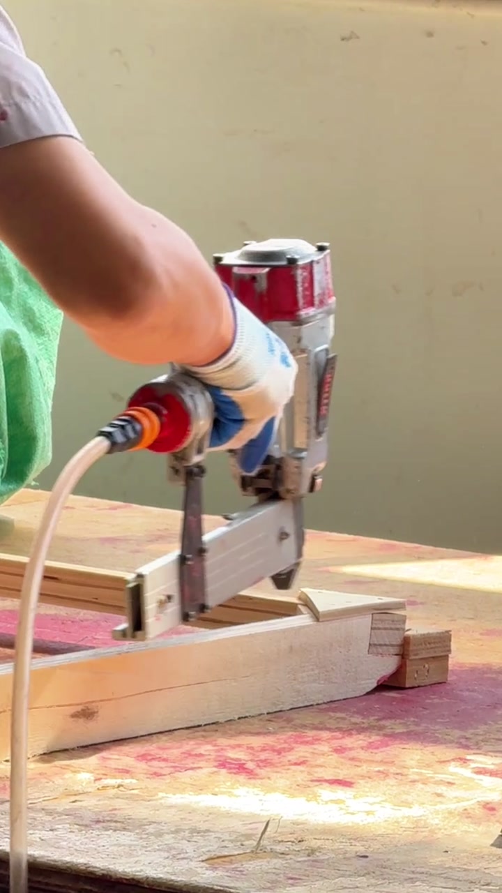A timber sofa frame being built on a factory floor.